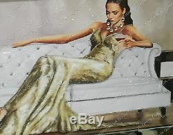 Lady sitting down in cream/gold dress with crystals & mirror frame picture